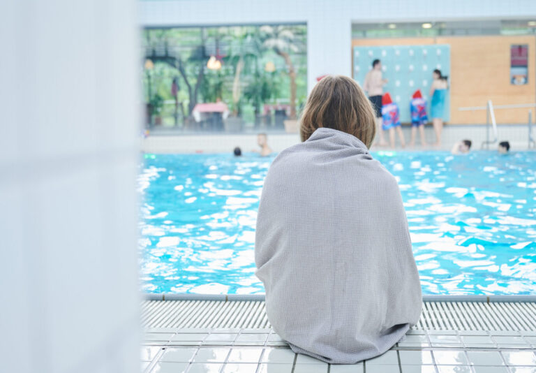 Mädchen sitzt am Rand eines Schwimmbeckens (Symbolbild): In der Haveltherme kam es in der Vergangenheit zu sexuellen Übergriffen. Foto: picture alliance/dpa | Annette Riedl
