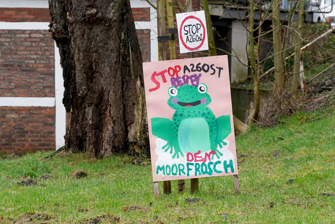 Blick auf ein Protestplakat mit der Aufschrift „Stop A26 Ost. Rettet den Moorfrosch“: Die CSU sagt Klagewellen der Umweltlobby jetzt den Kampf an. Foto: picture alliance/dpa | Marcus Brandt