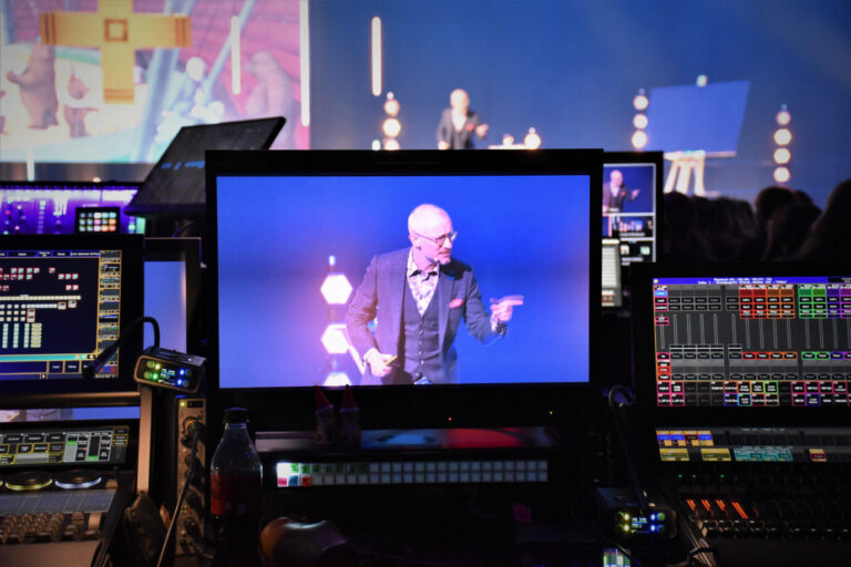 Johannes Hartl, katholischer Theologe, Missionar und Leiter des Augsburger Gebetshauses, spricht bei der Eröffnung der Christen-Konferenz "Weniger", am 5. Januar 2023 auf der Bühne der Messe in Augsburg. Die Aufnahme ist auf einem Monitor zu sehen.