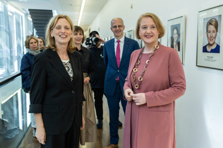 Zwei Frauen stehen bei einer Amtsübergabe im Bundesfamilienministerium nebeneinander, im Hintergrund ist ein Porträt einer früheren Ministerin zu sehen. Kontext: Die Förderung der Broschüre gegen rechte Jugendliche wurde vor Priens Amtsantritt bewilligt, die Veröffentlichung fällt in ihre Amtszeit. Karin Prien (links) und Lisa Paus bei der Amtsübergabe im Bundesfamilienministerium: Die Förderentscheidungen für das Projekt fielen unter Paus und ihrer Vorgängerin Franziska Giffey, deren Porträt an der Wand hängt. Foto: picture alliance/dpa/Revierfoto | Revierfoto