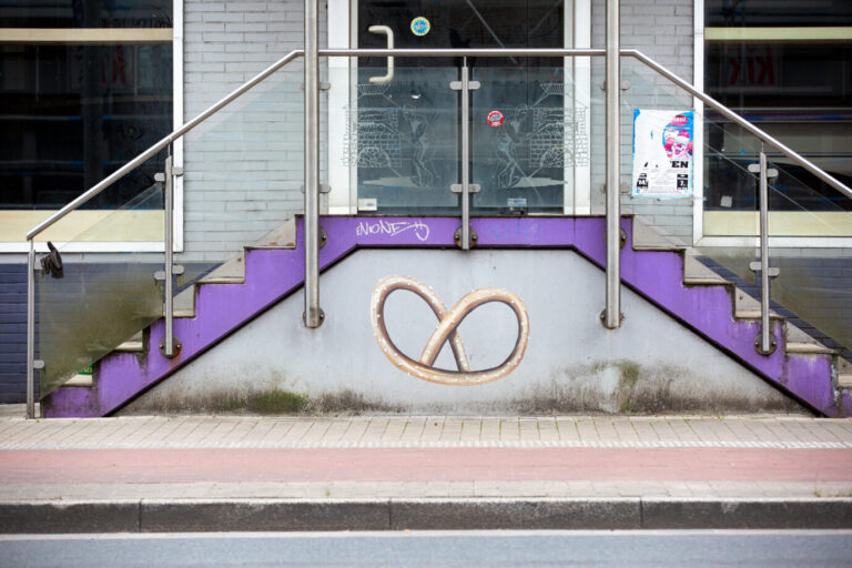 Eingang einer geschlossenen Bäckerei mit gemalter Brezel an der Wand. Symbolbild für wirtschaftliche Unsicherheit und pessimistische Stimmung in Umfragen zur Lage in Deutschland. Eingang mit Brezel zu einer geschlossenen Bäckerei: Mehrheit der Deutschen besorgt über wirtschaftlichen Niedergang. Foto: picture alliance / CHROMORANGE | Martin Schroeder