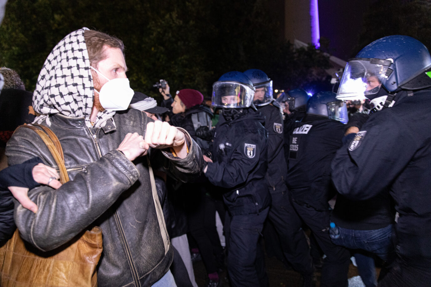 Mehrere Polizeibeamte in Schutzkleidung stehen Demonstranten gegenüber, einzelne Personen tragen Tücher und Masken, es kommt zu körperlichen Auseinandersetzungen. Aufnahme von Auseinandersetzungen bei einer pro-palästinensischen Demonstration in Berlin im Oktober 2025 im Zusammenhang mit politisch motivierter Gewalt. Auseinandersetzung zwischen Demonstranten und Polizei in Berlin: Linke Gewaltdelikte nahmen 2025 laut Bundesinnenministerium deutlich zu. Foto: picture alliance / ZUMAPRESS.com | Michael Kuenne