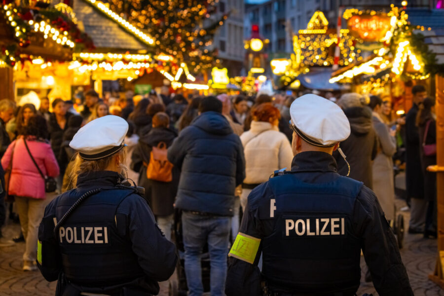 Polizisten patrouillieren auf einem Weihnachtsmarkt, der von Terror bedroht ist.