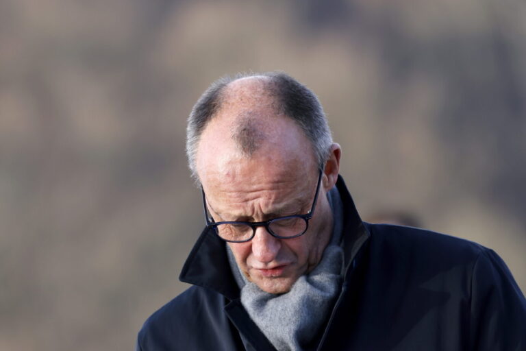 Bundeskanzler Friedrich Merz (CDU) bei der Eröffnung der Rahmedetalbrücke auf der A45 für den Verkehr. Die Brücke bildet ein Bindeglied in der Sauerlandlinie und musste nach einer Sprengung 2023 erneuert werden. Bundeskanzler Friedrich Merz steht mit gesenktem Blick im Freien, trägt dunklen Mantel, Schal und Brille. Aufnahme bei der Eröffnung der Rahmedetalbrücke auf der A45 in Lüdenscheid am 22. Dezember 2025, wenige Tage vor dem Stromausfall in Berlin. Bundeskanzler Friedrich Merz bei der Eröffnung der Rahmedetalbrücke auf der A45 in Lüdenscheid: Nach dem Stromausfall in Berlin blieb er öffentlich abwesend. Foto: picture alliance / Panama Pictures | Christoph Hardt