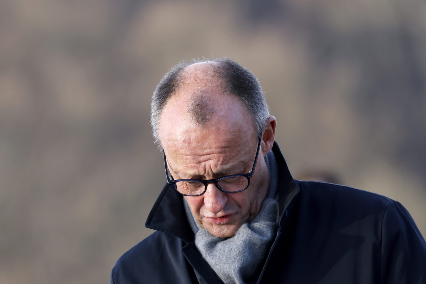 Bundeskanzler Friedrich Merz (CDU) bei der Eröffnung der Rahmedetalbrücke auf der A45 für den Verkehr. Die Brücke bildet ein Bindeglied in der Sauerlandlinie und musste nach einer Sprengung 2023 erneuert werden. Bundeskanzler Friedrich Merz steht mit gesenktem Blick im Freien, trägt dunklen Mantel, Schal und Brille. Aufnahme bei der Eröffnung der Rahmedetalbrücke auf der A45 in Lüdenscheid am 22. Dezember 2025, wenige Tage vor dem Stromausfall in Berlin. Bundeskanzler Friedrich Merz bei der Eröffnung der Rahmedetalbrücke auf der A45 in Lüdenscheid: Nach dem Stromausfall in Berlin blieb er öffentlich abwesend. Foto: picture alliance / Panama Pictures | Christoph Hardt