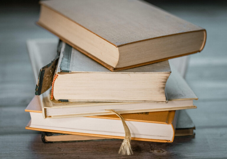 Auf einem Tisch liegt ein Stapel an Büchern – möglicherweise gefüllt mit Männerhaß