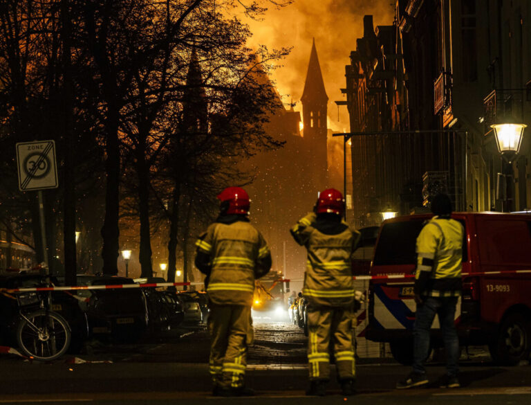 Zwei Feuerwehrleute stehen vor der Vondelkirche in Amsterdam, sie ging während der Silvesternacht in Flammen auf