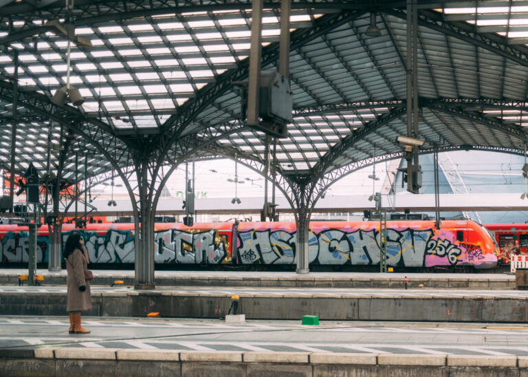 Bahnsteig mit einfahrendem Zug unter einer großen Stahl-Glashalle; Fahrgäste warten am Gleis. Kontext: Die Bundesregierung stuft detaillierte Informationen zum Zustand von Bahnanlagen als VS-Vertraulich ein. Warten auf den Zug: Zustandsdaten zu Bahnanlagen gelten als VS-Vertraulich. Foto: picture alliance / pressefoto Mika Volkmann | Mika Volkmann