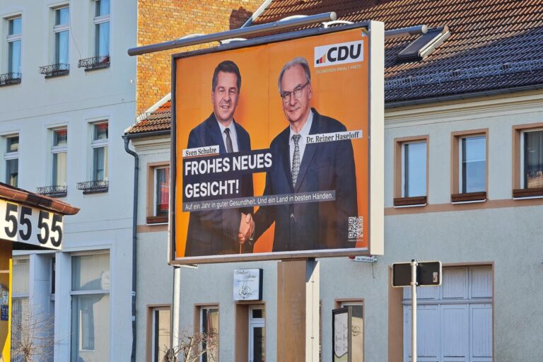 Aschersleben, Sachsen-Anhalt, Deutschland: Plakat mit Wirtschaftsminister Sven Schulze und Ministerpräsident Reiner Haseloff und dem Slogan "Frohes neues Gesicht - Auf ein Jahr in guter Gesundheit. Und ein Land in besten Händen". Die CDU kämpft im Jahr der Landtagswahl mit dem Problem, dass Spitzenkandidat Schulze nicht an die Bekanntheitswerte seines Vorgängers Haseloff kommt, und die AfD in Umfragen klar vorne liegt. Großflächiges Wahlplakat der CDU Sachsen-Anhalt an einer Straße, darauf Sven Schulze und Reiner Haseloff vor orangefarbenem Hintergrund beim Handschlag; Motiv verweist auf geplante Übergabe des Ministerpräsidentenamtes vor der Landtagswahl 2026. CDU-Plakat in Sachsen-Anhalt: Wirtschaftsminister Sven Schulze und Ministerpräsident Reiner Haseloff bei einem symbolischen Handschlag. Foto: picture alliance / dts-Agentur | -