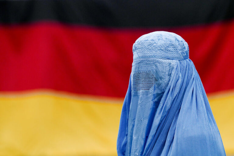 ILLUSTRATION - Eine Frau trägt eine Burka vor einer Deutschlandfahne am 26.08.2017 in Leipzig (Sachsen, gestellte Szene). Foto: Peter Endig/dpa-Zentralbild/ZB
