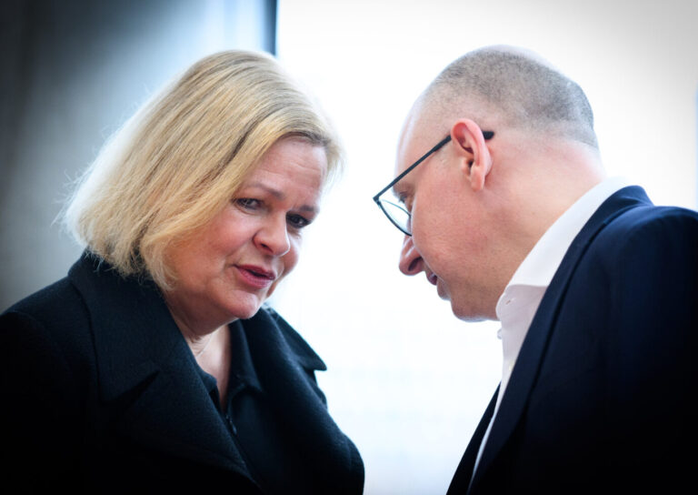 Nancy Faeser (SPD) und Sinan Selen beugen sich im Paul-Löbe-Haus zueinander und sprechen leise miteinander; Aufnahme zu Beginn einer Sondersitzung des Innenausschusses zum Anschlag auf den Weihnachtsmarkt in Magdeburg. Nancy Faeser und Sinan Selen im Gespräch am Rande einer Ausschußsitzung: Vertraulicher Austausch vor laufenden Kameras. Foto: picture alliance/dpa | Bernd von Jutrczenka