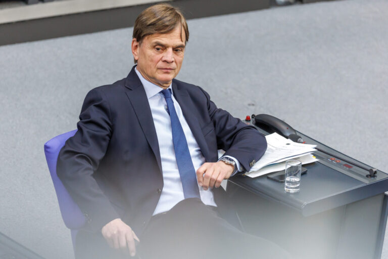 Karlsruhe vergleicht den Anspruch der AfD auf einen größeren Sitzungssaal mit dem Kampf um die Silbermedaille. Im Interview mit der JUNGEN FREIHEIT sagt Bernd Baumann, warum die Fraktion die Entscheidung für grundfalsch hält. Mann im Anzug sitzt im Plenarsaal des Deutschen Bundestages an einem Abgeordnetenplatz, vor ihm Unterlagen, ein Glas Wasser und ein Rednerpult. AfD-Fraktionsführung im Bundestag im Kontext der Karlsruher Entscheidung zum Fraktionssitzungssaal und zu Oppositionsrechten. Bernd Baumann im Deutschen Bundestag: Der Erste Parlamentarische Geschäftsführer der AfD-Fraktion Kritisiert im Gespräch mit der JF die Karlsruher Entscheidung zum Sitzungssaal. Foto: picture alliance / Andreas Gora | Andreas Gora