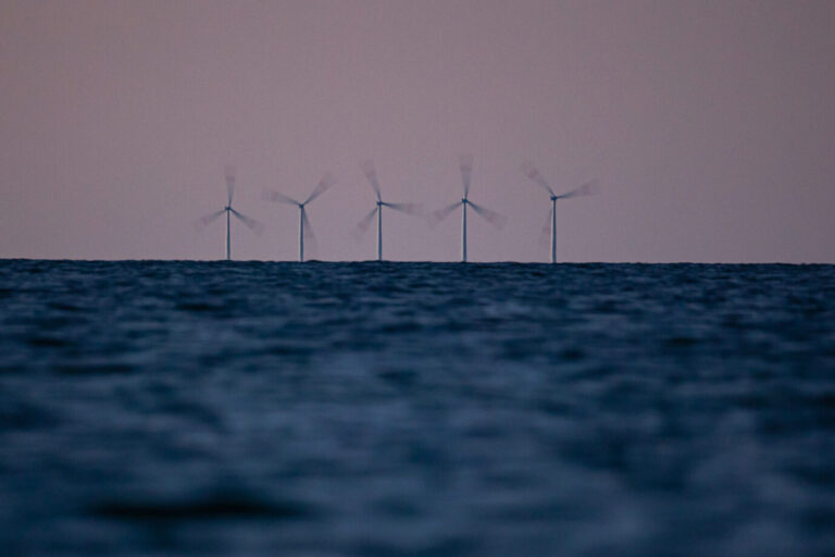 Eine dunkle Wasserfläche, in der Ferne Windräder: Es handelt sich um Windkraftanlagen des Offshore Windpark Baltic 1 des Energiekonzern EnBW Energie Baden-Württemberg AG. Daß die Firma ihre Offshore-Projekte in Großbritannien jetzt abgesagt hat, zeigt, wie die Energiewende scheitert
