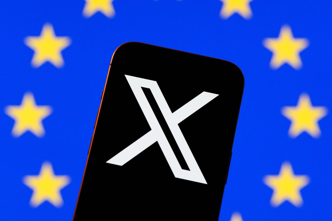 Ein Smartphone mit dem X-Logo vor einer EU-Flagge. Die Zensur aus Brüssel soll massiv um sich greifen.