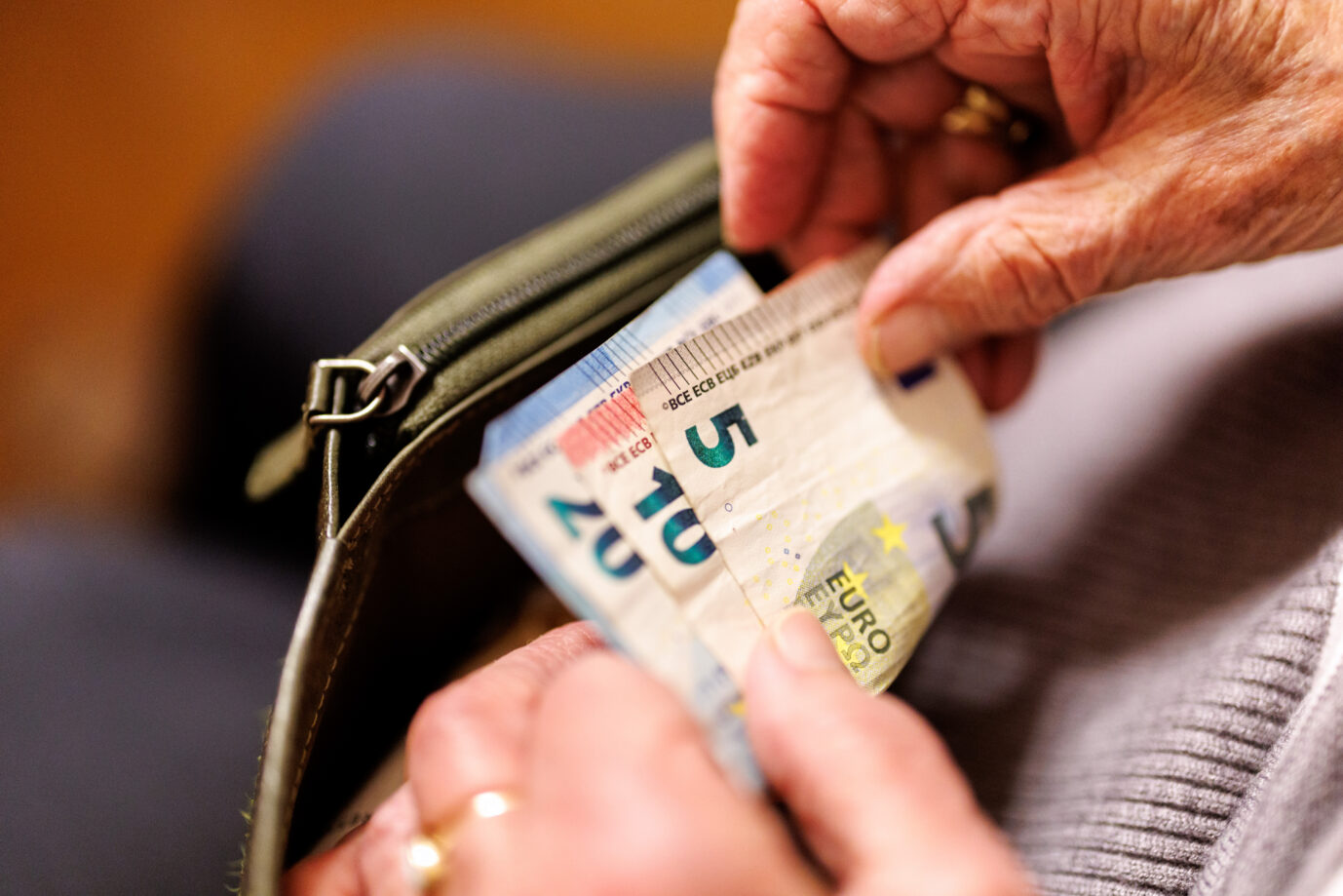Frau nimmt Geldscheine aus ihrer Brieftasche (Symbolbild): Der Wirtschaftsrat setzt bei Kassen- und Sozialleistungen den Rotstift an