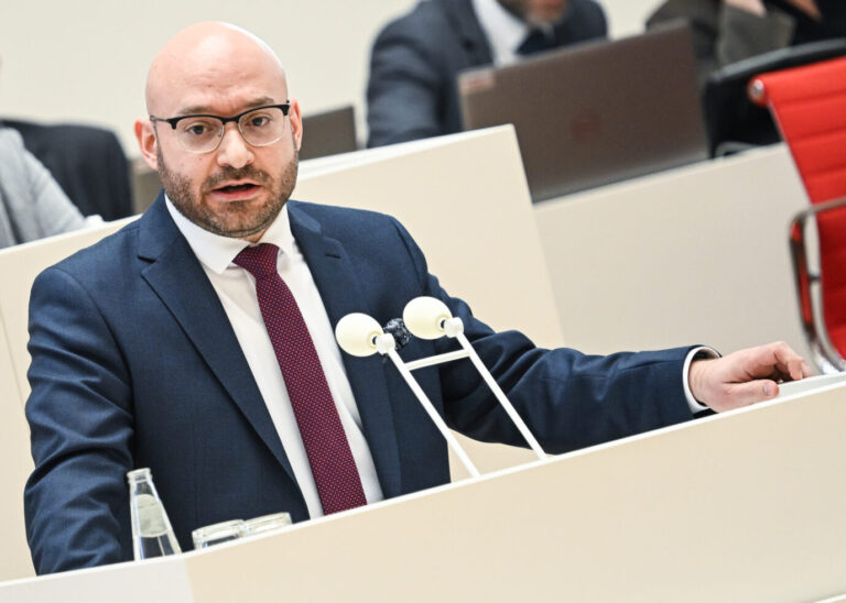 René Wilke spricht am Rednerpult im Brandenburger Landtag, vor ihm Mikrofone und Unterlagen. Der Innenminister verteidigt die Nutzung verdeckter Fake-Profile durch den Landesverfassungsschutz. Brandenburgs Innenminister René Wilke (SPD) im Landtag: CDU und SPD lehnen einen Stopp der verdeckten Fake-Profile des Verfassungsschutzes ab. Foto: picture alliance/dpa | Britta Pedersen