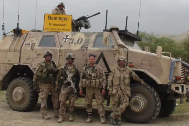 Bundeswehr-Kameraden vor einem gepanzerten Fahrzeug, darunter Christoph Heurich