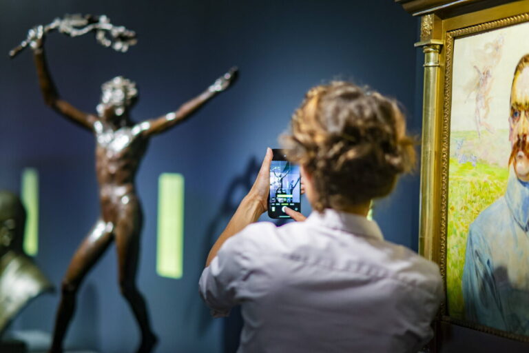 Vorne steht eine Frau mit einem Handy, sie fotografiert eine Statue. Die Ausstellung „Freiheit“ im Deutschen Hygiene Museum will Debattenräume abdecken.