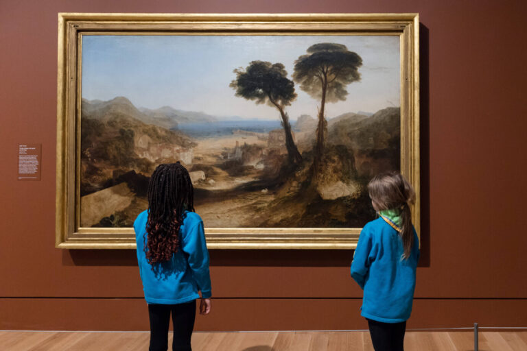 Zwei Mädchen stehen vor einem Gemälde – es handelt sich um Besucher der Turner-Constable-Ausstellung in London