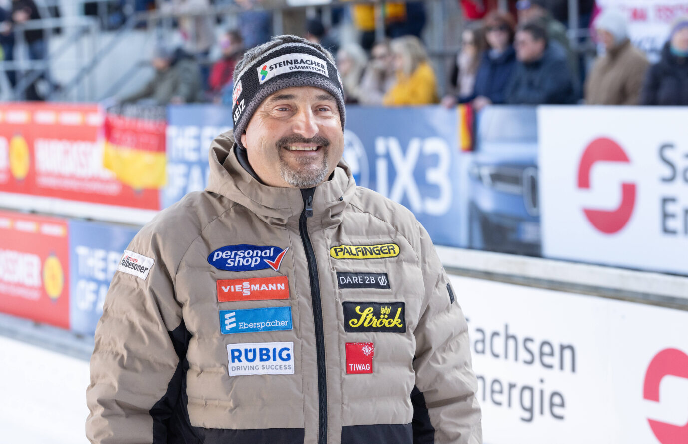 Georg Hackl an einer Rodelbahn: Der frühere Olympiasieger kritisiert Deutschlands Infrastrukturpolitik scharf. Georg Hackl in Winterjacke und Mütze an einer Rodelbahn, im Hintergrund Zuschauertribüne. Der frühere Olympiasieger kritisiert in einem Interview Deutschlands Infrastrukturpolitik und spricht von einer „Bananenrepublik“.