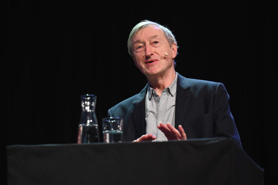 Der Schriftsteller Julian Barnes trägt ein schwarzes Jackett und gestikuliert – er schreibt über den Tod