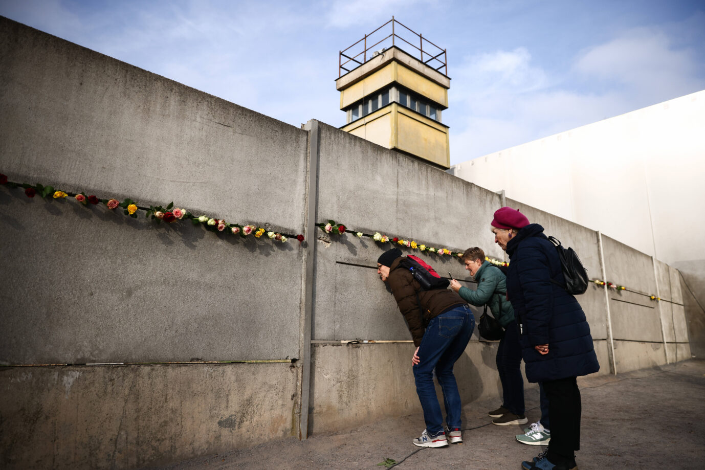 An einem Überbleibsel der Berliner Mauer stehen Besucher – bald soll in Berlin ein großes Denkmal für die Opfer der DDR entstehen