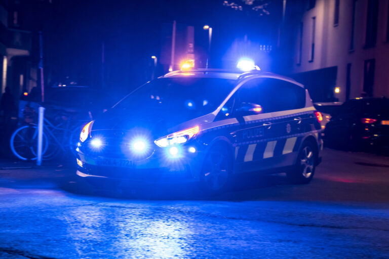 Ein Polizeiauto fährt mit Blaulicht – vermutlich, weil ein Iraker mit einer Pistole auf ein Wohnhaus schießt