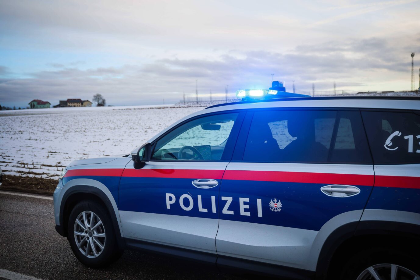 Ein Fahrzeug der österreichischen Polizei fährt mit Blaulicht über eine Landstraße – bestimmt hat wieder ein Syrer randaliert
