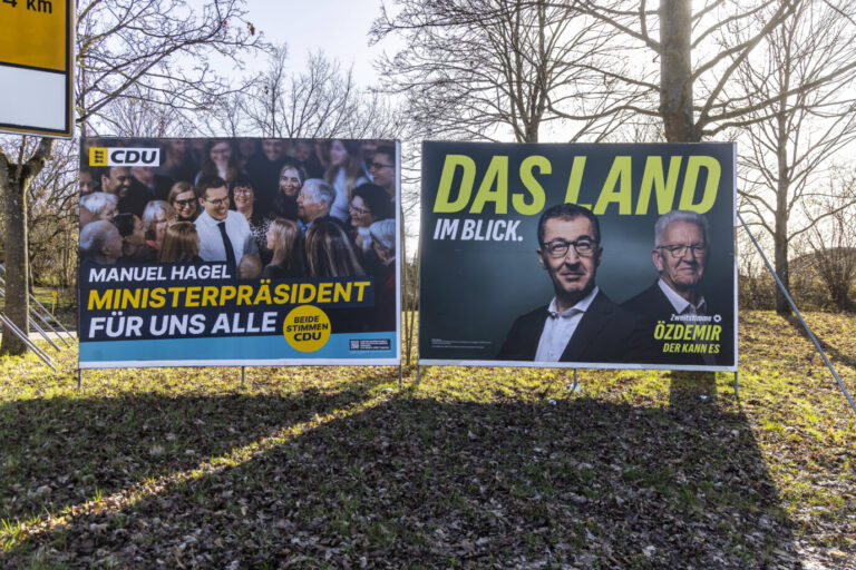 Auf einer grünen Wiese sind zwei große Wahlplakte ausgestellt, sie zeigen die Spitzenkandidaten Hagel (CDU) und Özdemir (Grüne) – es ist Landtagswahlkampf in Baden-Württemberg