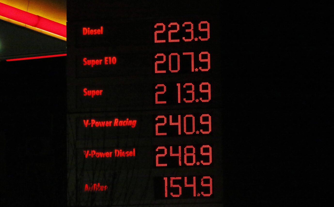 Elektronische Preistafel einer Tankstelle bei Dunkelheit. In roter LED-Schrift werden die aktuellen Spritpreise angezeigt, darunter Diesel mit 2,23 Euro, Super E10 mit 2,07 Euro, Super mit 2,13 Euro sowie weitere Kraftstoffsorten mit noch höheren Preisen. Links sind die Kraftstoffarten aufgelistet, rechts stehen die zugehörigen Preise. Preisanzeige einer Tankstelle: Künftig dürfen Kraftstoffpreise nur noch einmal täglich zu einem festen Zeitpunkt angehoben werden. Foto: IMAGO / SNS UG