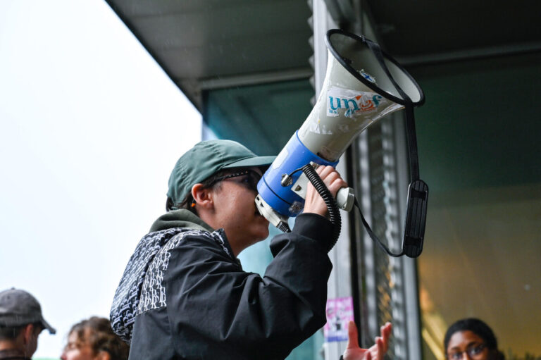 Ein junger Mann hält ein Megaphon in der Hand – es handelt sich um einen Studenten der Universität Lyon 2, der an einem linksextremen Protest teilnimmt