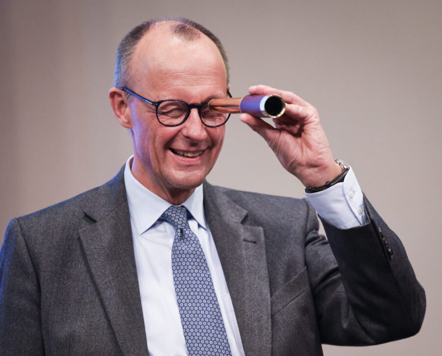 Friedrich Merz, Bundesvorsitzender der CDU und Kanzlerkandidat der Union, schaut durch ein kleines Fernrohr das er nach seiner Rede beim Neujahrsempfang der CDU Rendsburg-Eckernförde in der ACO Thormannhalle als Geschenk erhalten hat. Bundesregierung will Vorratsdatenspeicherung.
