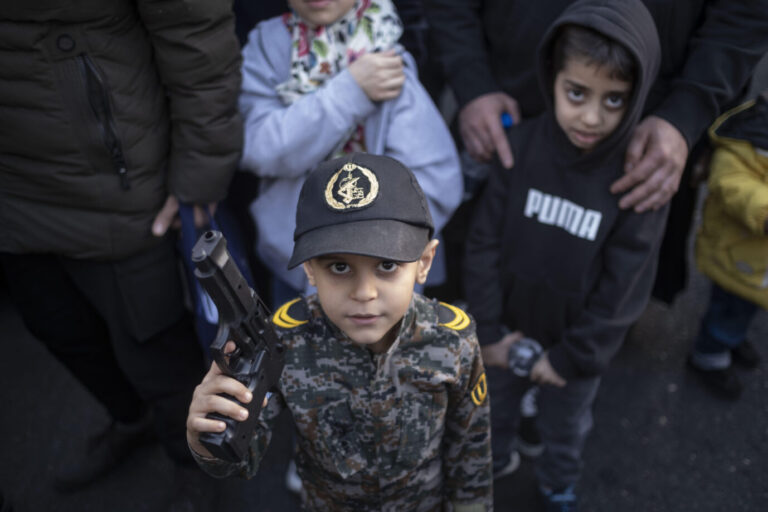 Ein Kind im Iran posiert mit einer Pistole.