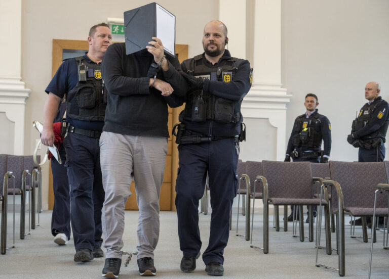 Der Islamlehrer verdeckt im Landgericht sein Gesicht: Zur eigenen Lustbefriedigung soll er Kinder mit Öl massiert haben. picture alliance/dpa | Stefan Puchner