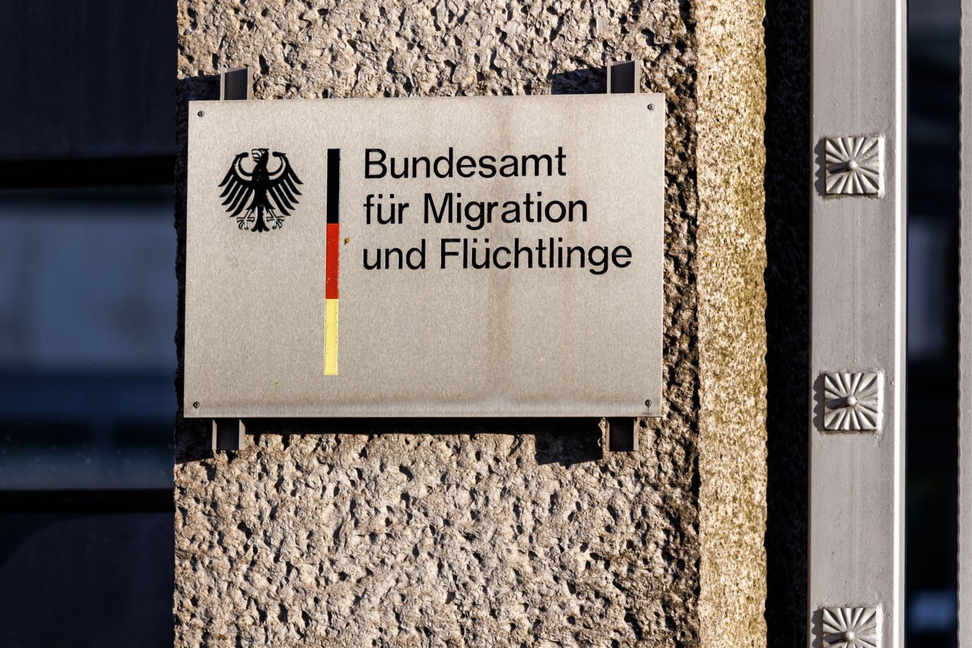 Der Schriftzug „Bundesamt für Migration und Flüchtlinge“ und das deutsche Wappentier, der Bundesadler, sind auf einer Säule beim deutschen Bundesamt für Migration und Flüchtlinge (BAMF) in Nürnberg (Bayern) zu sehen. Das Bundesamt für Migration und Flüchtlinge (BAMF) ist eine deutsche Bundesoberbehörde im Geschäftsbereich des Bundesministeriums des Innern und für Heimat (BMI) und das Kompetenzzentrum für Asyl, Migration und Integration in Deutschland. (Gebäude, Außenaufnahme, Außenansicht, Symbolbild, Symbolfoto, Illustration, symbolisches Foto, illustratives Foto, Themenbild, allgemeines Bild, Themenfoto)