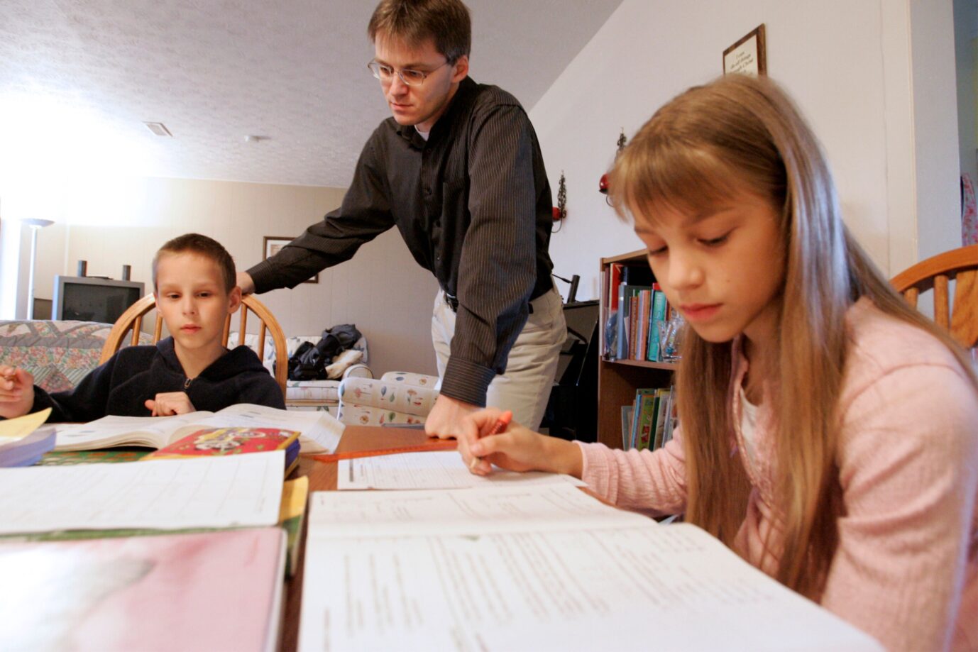 Uwe Romeike arbeitet am 13. Maerz 2009 in seinem Heim in Morristown, Tennesse, USA, mit seinen Kindern Josua, links, und Lydia, rechts, an den Hausaufgaben. Weil sie die allgemeine Schulpflicht nicht mit ihrem Glauben vereinbaren koennen, haben Uwe und Hannelore Romeike in den USA einen Antrag auf politisches Asyl gestellt. Sie bestehen darauf, ihre fuenf Kinder daheim zu unterrichten, was in Deutschland nicht moeglich ist.