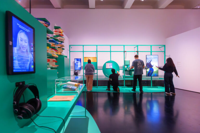 Menschen stehen vor Bildschirmen, tanzen, drücken auf Knöpfe: Besucher der Ausstellung "Wie geht's" im Deutschen Hygiene-Museum. Die Psyche machts.