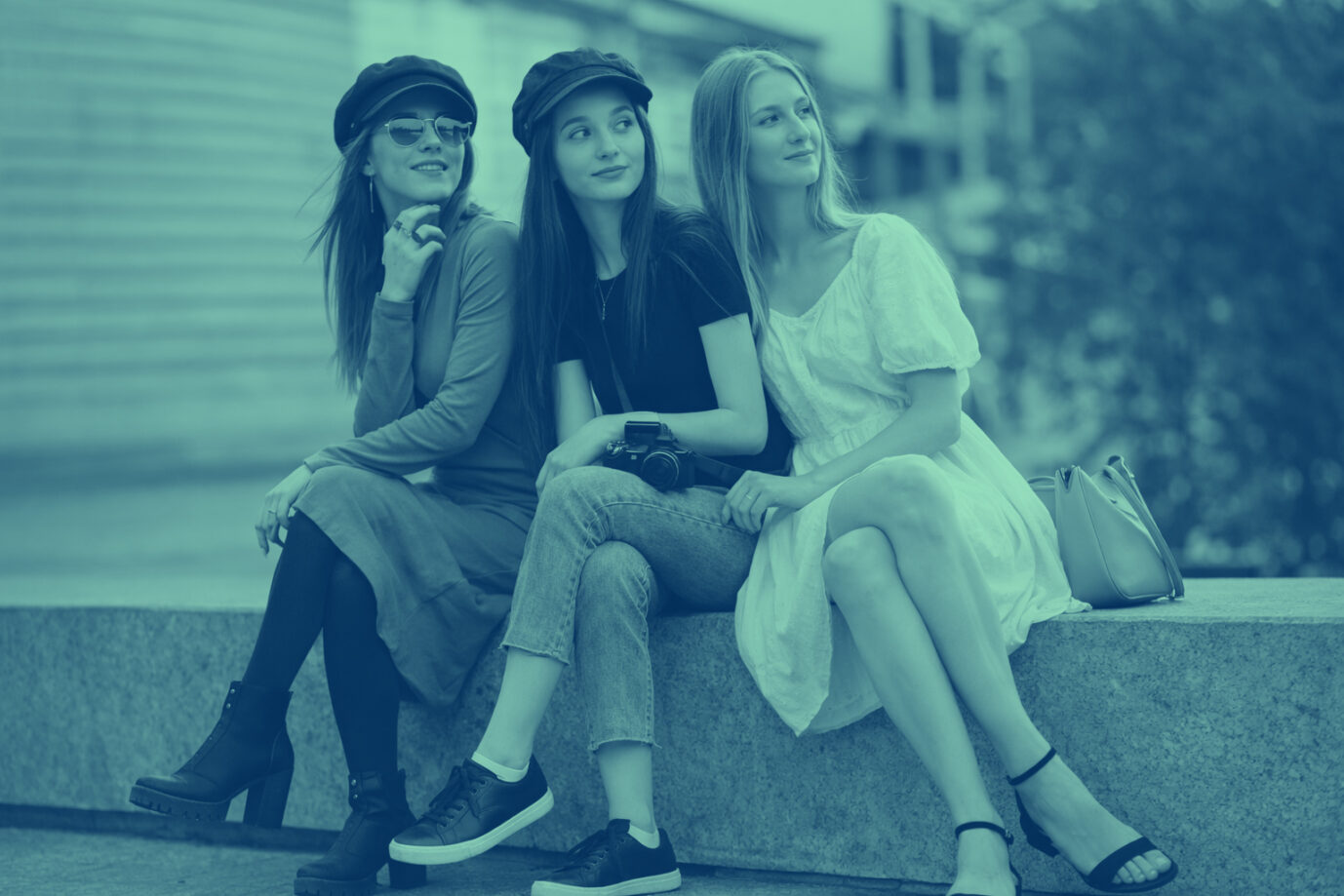 Auf einer Bank sitzen drei hübsche junge Frauen