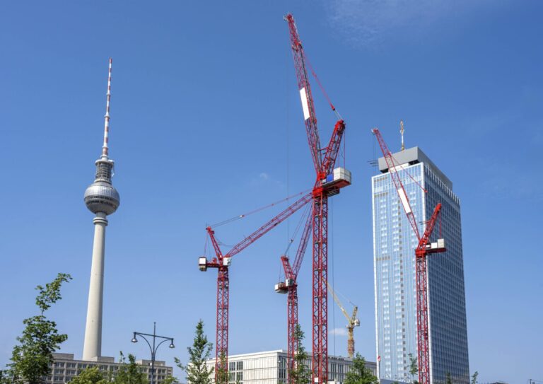 Der Berliner Fernsehturm und rote Baukräne. Der Wohnungsbau ist teuer, die Baukosten und Preise für Grundstücke schießen in die Höhe.