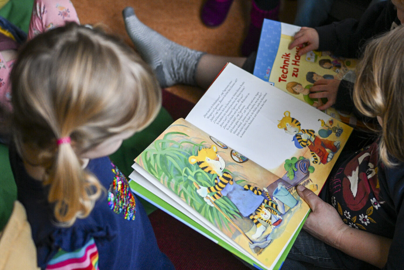 Eine Erzieherin liest ein Kinderbuch vor: Das Hessische Kultusministerium fördert, dass Kindern die Schwangerschaft schlechtgeredet wird. Foto: picture alliance/dpa | Jens Kalaene