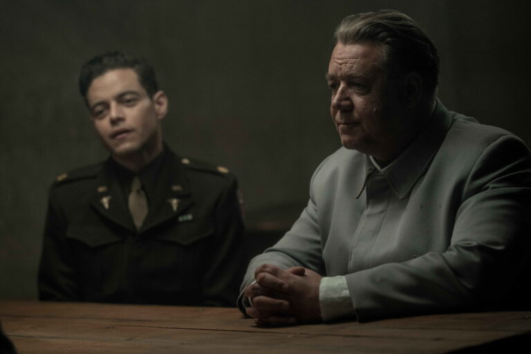 Links sieht man Rami Malek in seiner Rolle als Psychater Douglas Kelley, daneben sitzt Russel Crowe in seiner Rolle als Hermann Göring, beide im Film „Nürnberg“