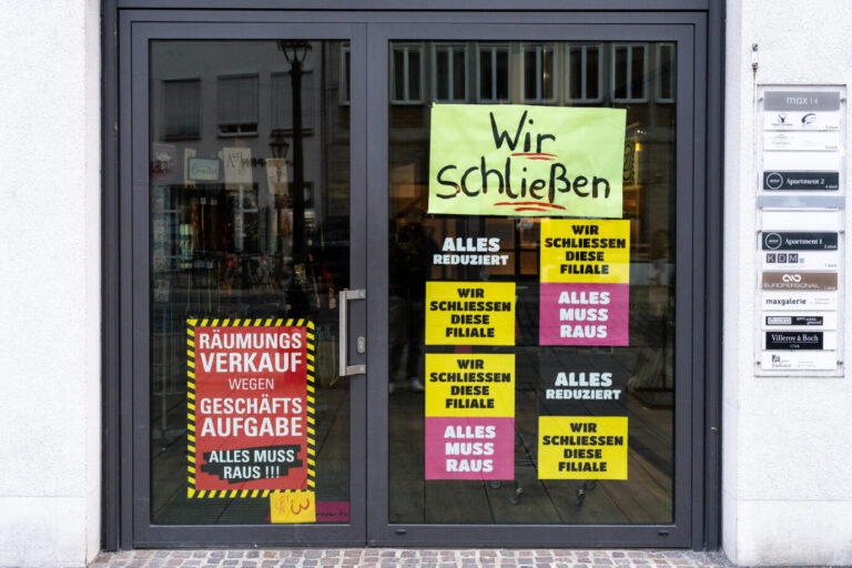 Hinweisschilder: Wir schließen, und: Alles reduziert, an einem Ladengeschäft in der Innenstadt. Immer mehr Filialen müssen aufgrund von Inflation, sinkender Kaufkraft und der anhaltenden Wirtschaftskrise schließen. Die Konsumstimmung ist schlecht. Ein Symbol für das zunehmende Innenstadtsterben
