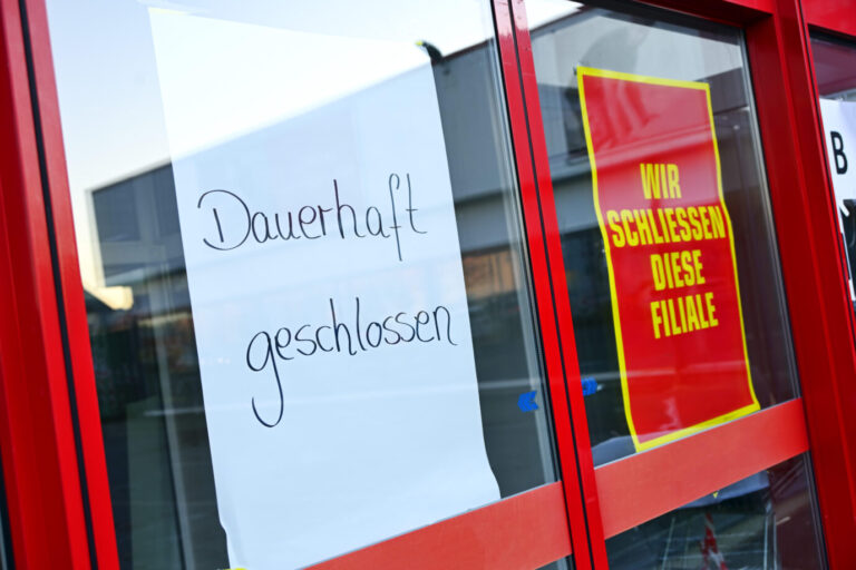 Schilder mit Aufschrift Dauerhaft geschlossen und Wir schließen diese Filiale, Symbolfoto Konkurs, Insolvenz