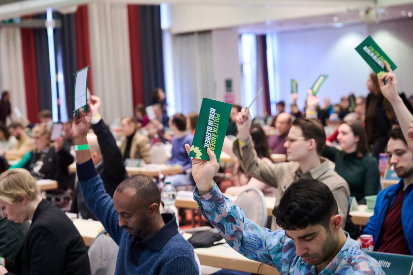 Parteimitglieder halten Stimmkarten bei einer Abstimmung der Grünen in die Luft. Gegen eine geplante Parteireform laufen viele Mitglieder Sturm. Foto: picture alliance/dpa | Annette Riedl