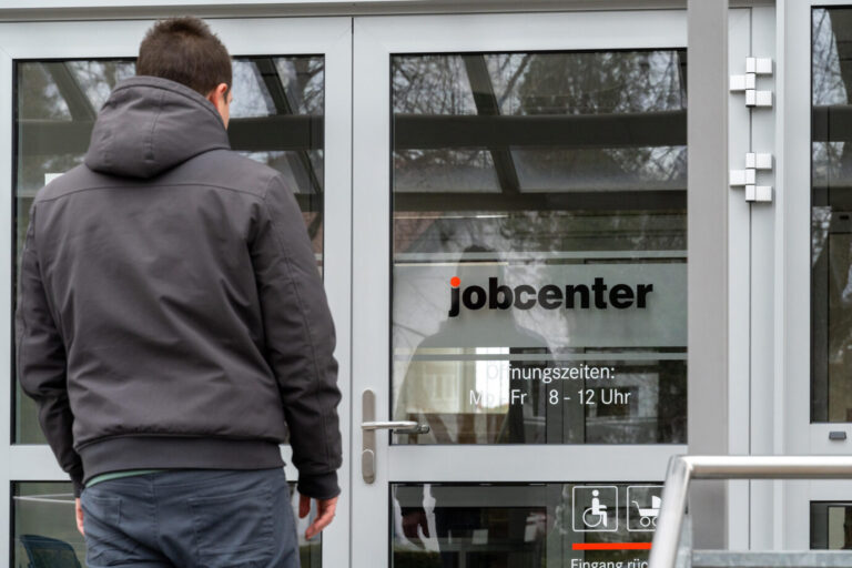 Ein junger Mann steht vor dem Eingang eines Jobcenters. Die Bundesagentur für Arbeit geht gegen Sozialleistungsbetrug vor.