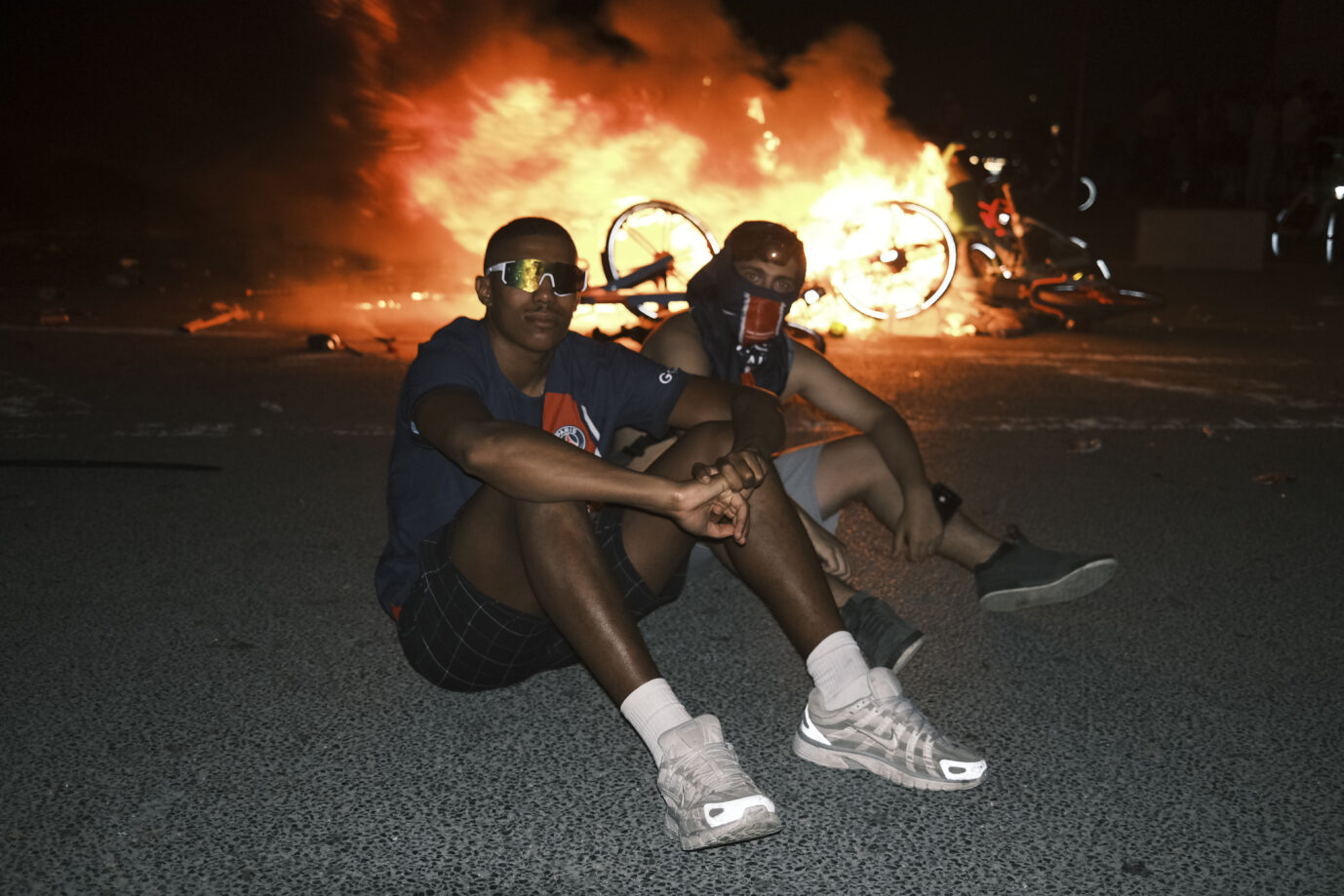 Frankreich: Paris Saint-Germain Anhänger sitzen vor einer brennenden Barrikade.