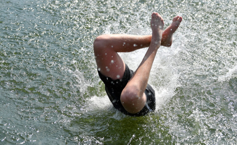 Ein Badegast springt im Heidebad in Halle/Saale von einer Insel ins Wasser des Sees. Bei Temperaturen um 38 Grad ist am bislang heißesten Tag in diesem Jahr jede Abkühlung willkommen.