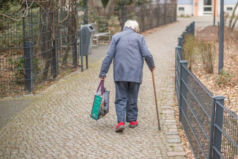 Eine ältere Dame mit Gehstock und Einkaufstasche (Symbolbild): Rund 5,2 Millionen Menschen beträfe die Abschaffung der Witwenrente. Foto: IMAGO / Dirk Sattler