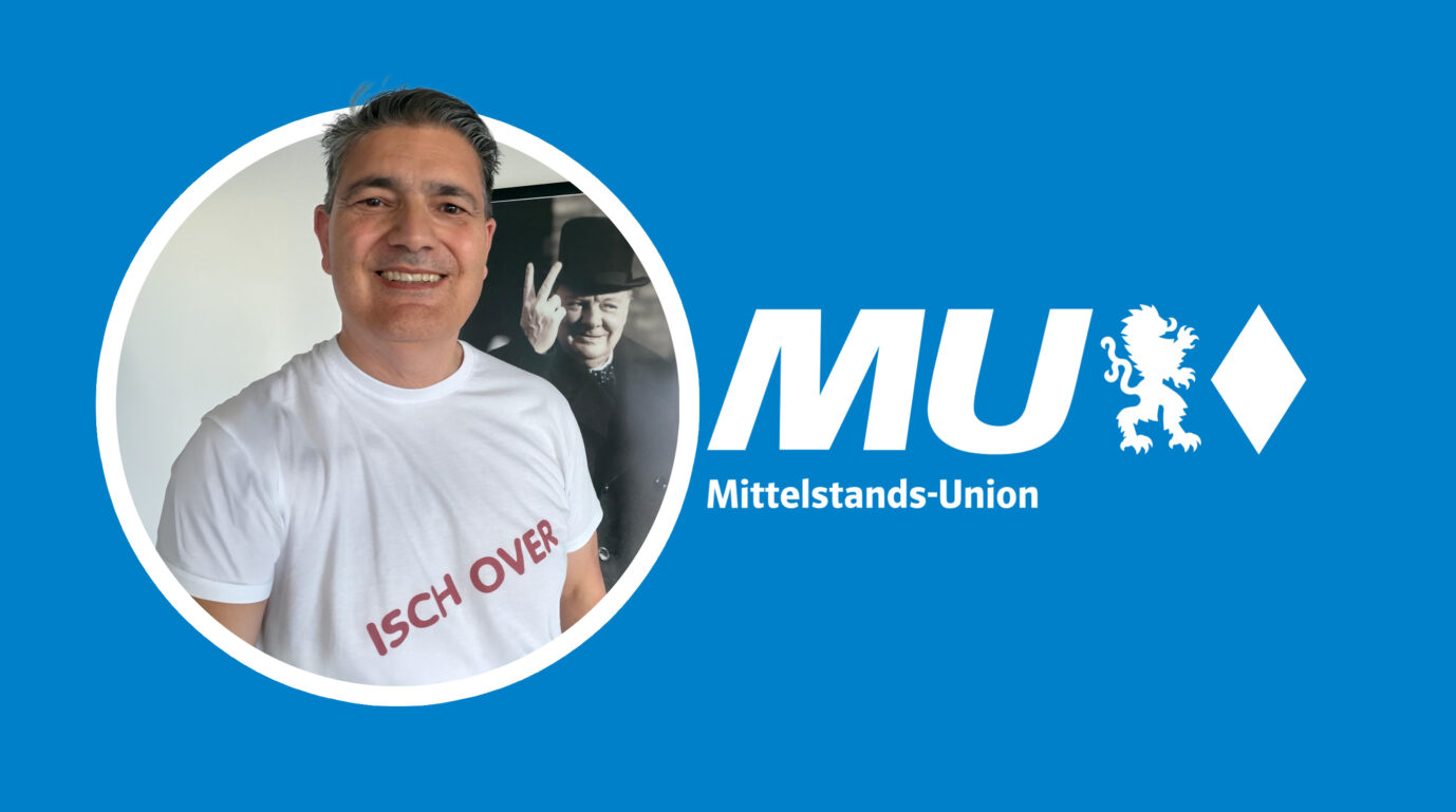 Freundlich lächelnd steht er da: Der ehemalige Vize-Chef der Mittelstandsunion und Kreisvorsitzende der Hofer Mittelstandsunion, Michael Kretzer, neben dem Logo der Organisation