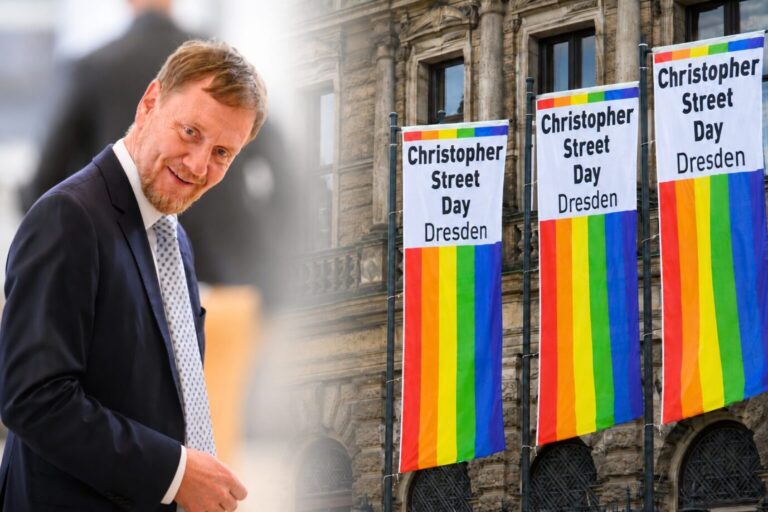 Sachsens Ministerpräsident Michael Kretschmer und Fahnen des CSD in Dresden.